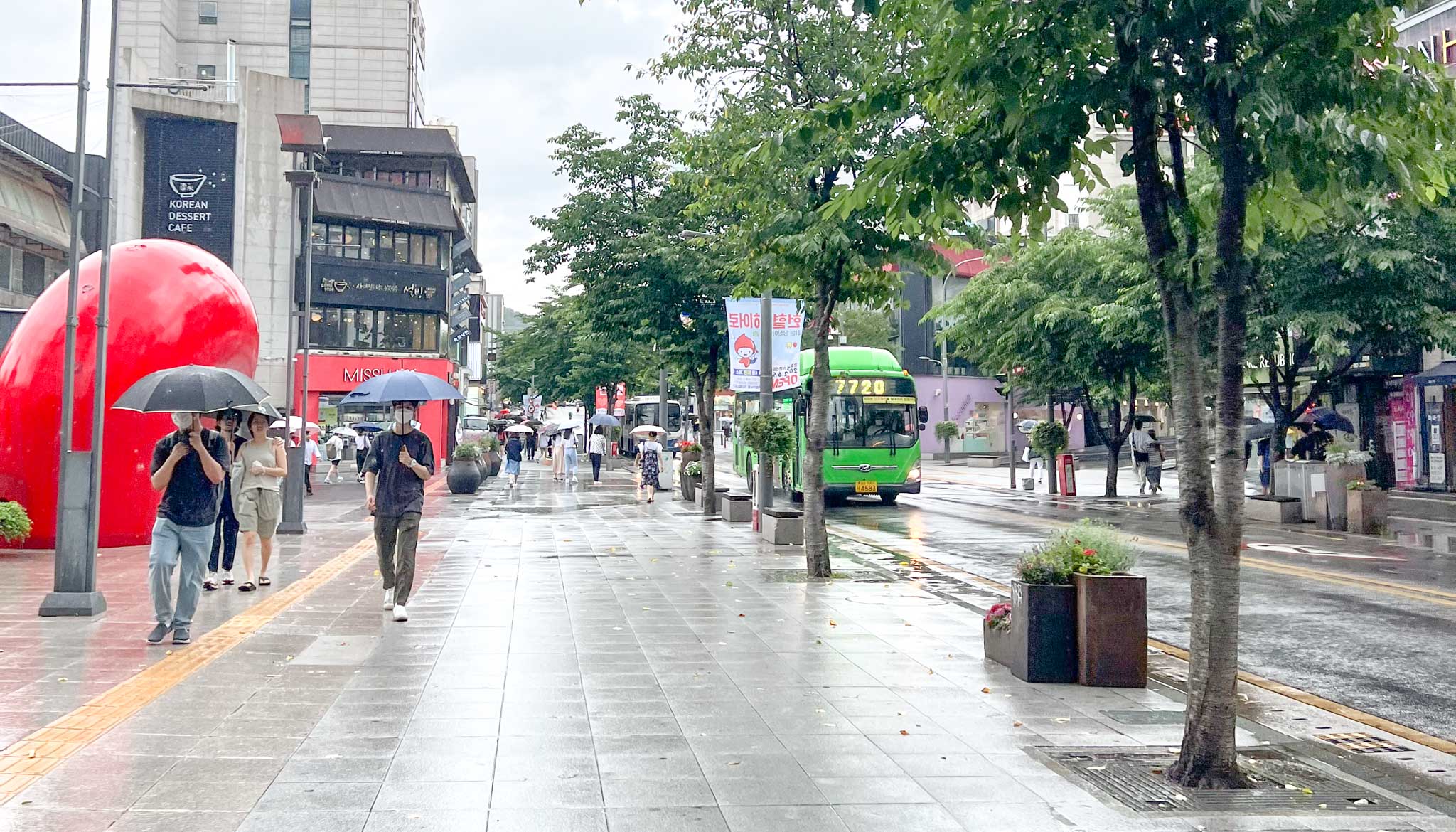 people with umbrellas in Seoul during the rain